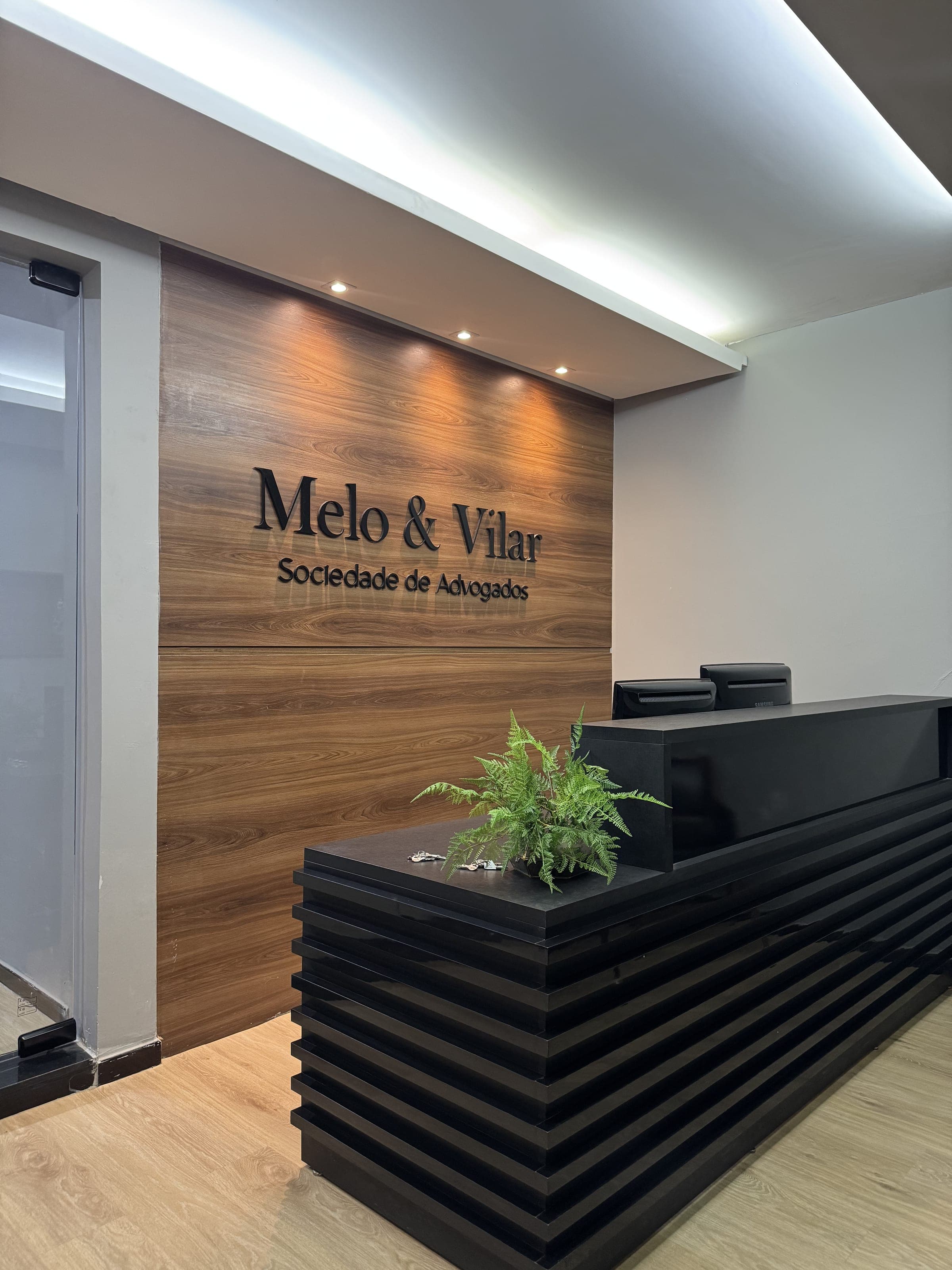 Recepção do escritório com o logotipo Melo & Vilar